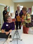 The FL-GA District VP of Communications, Joan, signs women up to receive the newsletter, "Evangel."